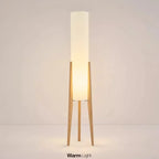 Modern floor lamp with wooden legs and a cylindrical shade