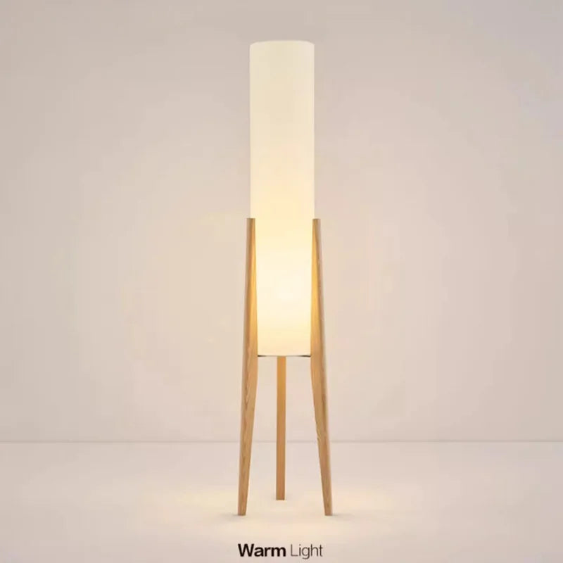 Modern floor lamp with wooden legs and a cylindrical shade
