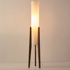 Modern floor lamp with wooden legs and a cylindrical shade