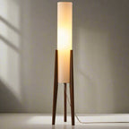 Modern floor lamp with wooden legs and a cylindrical shade