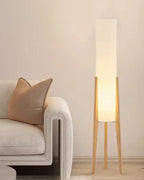 Modern floor lamp with wooden legs and a cylindrical shade